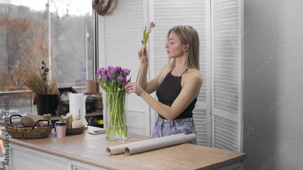 A young beautiful woman engaged in floristry begins to collect the best flowers for her flower arrangement. Floristry A young beautiful woman engaged in floristry begins to collect the best flowers for her flower arrangement. Floristry