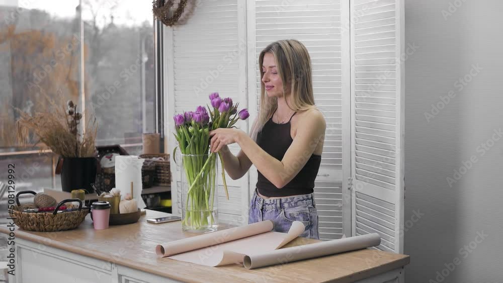 A young beautiful woman engaged in floristry begins to collect the best flowers for her flower arrangement. Floristry A young beautiful woman engaged in floristry begins to collect the best flowers for her flower arrangement. Floristry