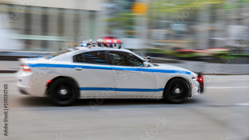 Police car moving fast on city street