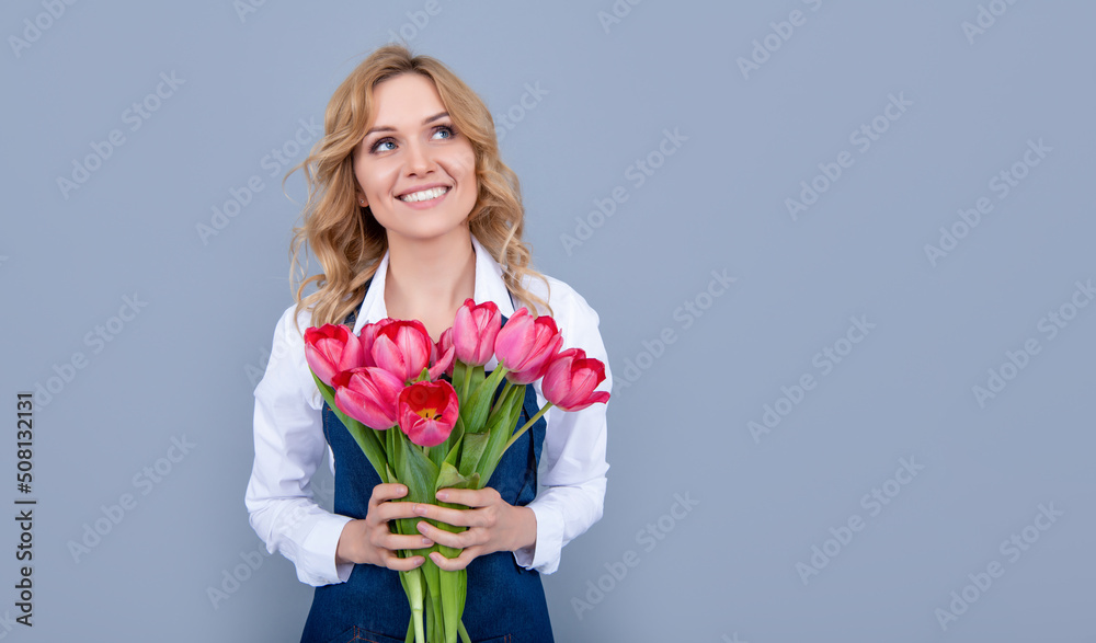 glad flower seller woman in apron with spring tulip flowers on grey background glad flower seller woman in apron with spring tulip flowers on grey background