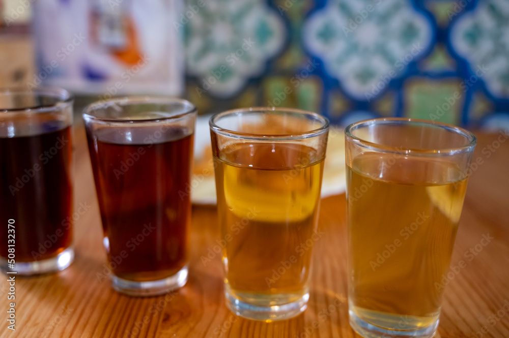 Tasting of different sweet wines from wooden barrels on old bodega in central part of Malaga, Andalusia, Spain Tasting of different sweet wines from wooden barrels on old bodega in central part of Malaga, Andalusia, Spain