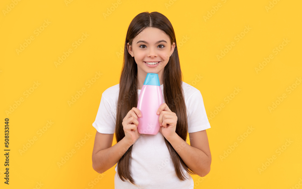 happy child holding shampoo bottle on yellow background, cosmetic happy child holding shampoo bottle on yellow background, cosmetic