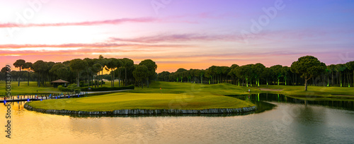 Sunset at the golf course. Scenic panoramic view of golf fairway