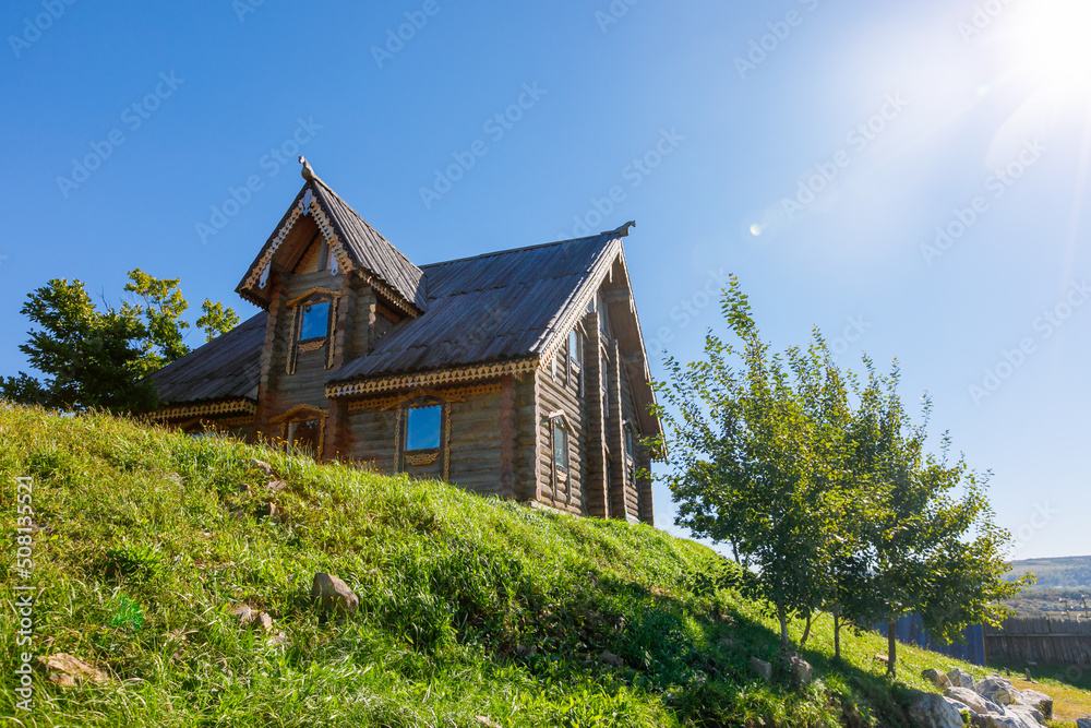 Russian wooden hut against the blue sky. Old village hut. Peasant dwelling.