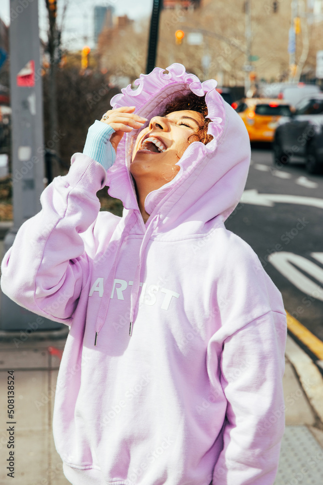 Obraz premium African American woman wearing pink hoodie outside in city