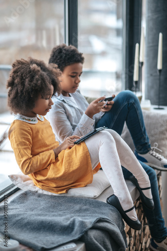 Two kids spending time online using their devices