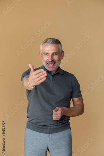 A man in a grey tshirt stretching his arm forward