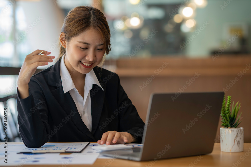 Happy Asian businesswoman laughing sitting at the work desk with laptop, a cheerful smiling female employee having fun feeling joy and positive emotion express sincere laughter at office workplace Happy Asian businesswoman laughing sitting at the work desk with laptop, a cheerful smiling female employee having fun feeling joy and positive emotion express sincere laughter at office workplace