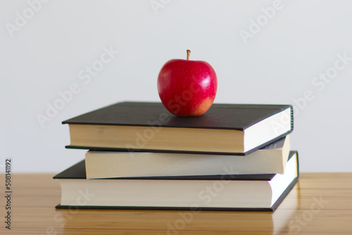 机の上に積み重ねた本とりんご