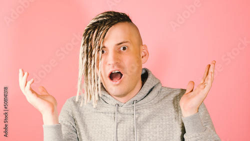 Canvas Print Young handsome shocked man looking at camera with horror on pink background