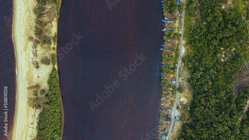 Aerial drone view of many fishing boats by the riverside in Kampung Badong, Kuala Rompin, Pahang, Malaysia.