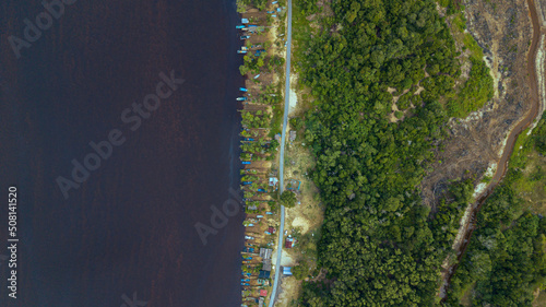 Aerial drone view of many fishing boats by the riverside in Kampung Badong, Kuala Rompin, Pahang, Malaysia. photo