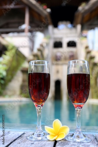 glasses with red wine near the swimming pool in the tropics
