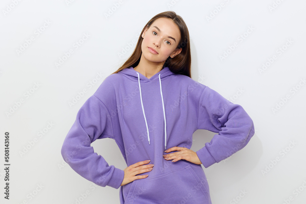 a sweet attractive woman stands on a white background in a purple tracksuit, slightly smiling, put her hands on her belt