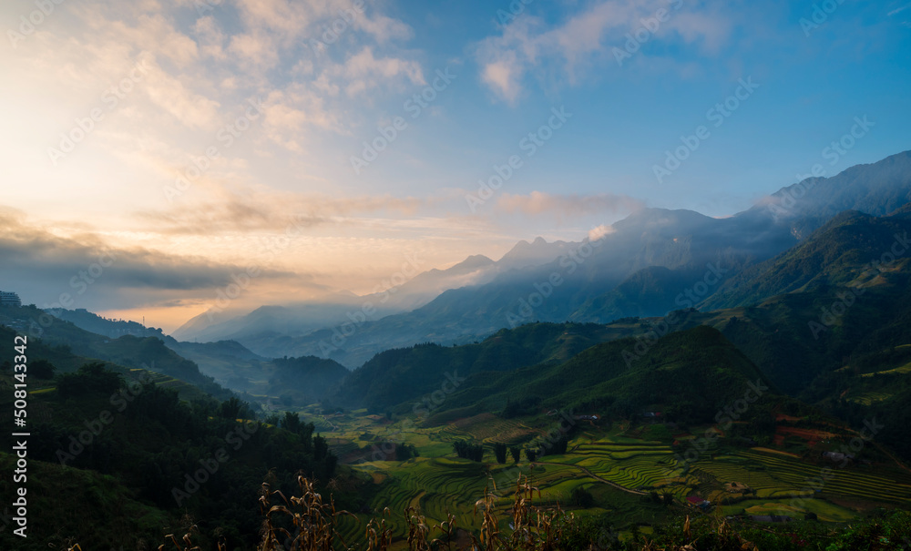 Dramatic sunset over mountain landscape. Beautiful landscape foggy hills twilight time. Blue golden sky sunrise dramatic beautiful landscape mountain. Dawn sky gold dusk time cloudscape with sunlight