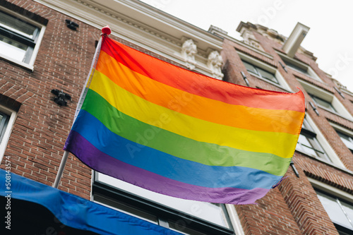 Pride month rainbow pride parade flag on flagpole. Equal rights, lqbtq pride month against gay, lesbian, bisexual, transgender discrimination.