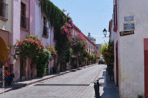 Calles del Centro Histórico de Querétaro calle Ocampo de día con flores y buganvilias.