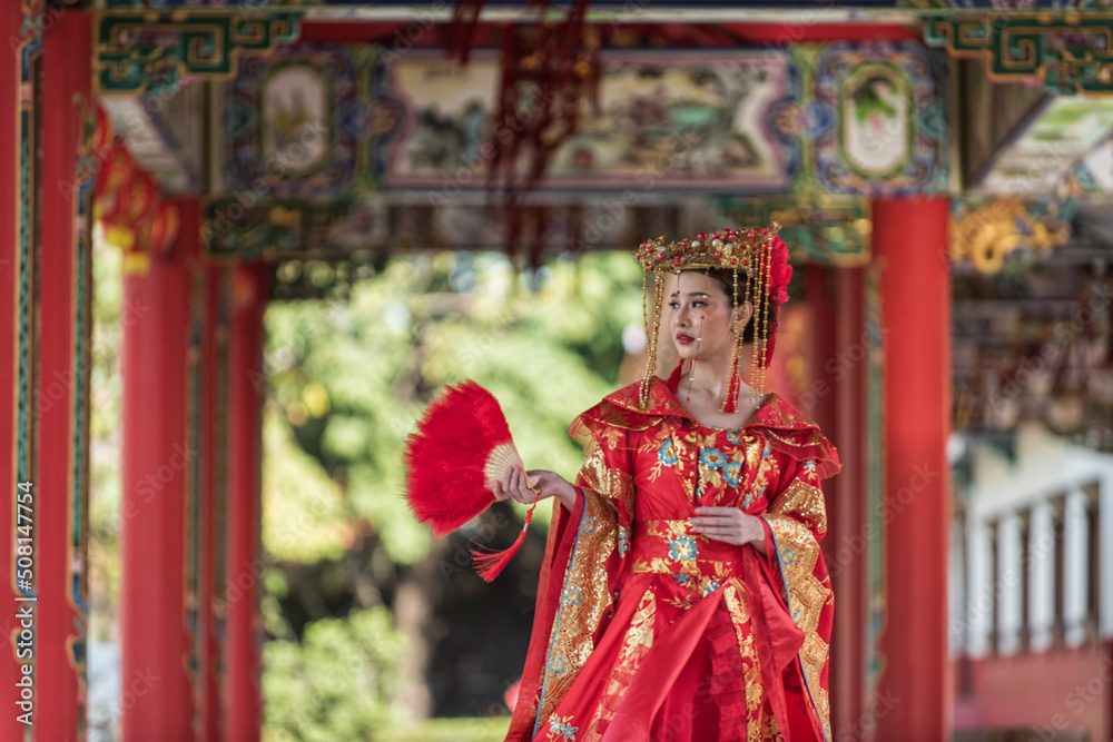 Portrait of a woman. portrait of a woman. person in traditional costume. woman in traditional costume. Beautiful young woman in a bright red dress and a crown of Chinese Queen posing. 