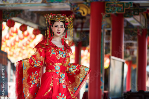 Portrait of a woman. portrait of a woman. person in traditional costume. woman in traditional costume. Beautiful young woman in a bright red dress and a crown of Chinese Queen posing.  © VIEWFOTO STUDIO