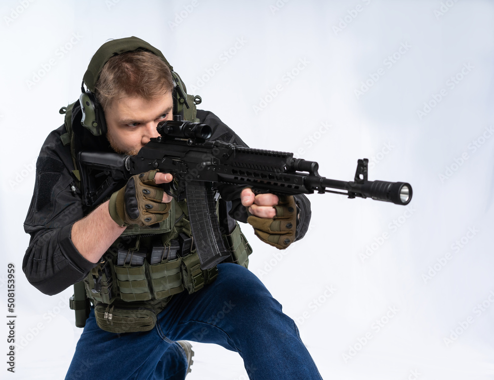 Airsoft player holds a rifle, a weapon with an optical sight. Soldier on alert. war concept. isolated background. Armed conflict. Russia Ukraine. military operation