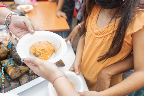 Unrecognizable girl receiving a plate with nacatamal from Nicaragua, a typical dish from Latin America photo