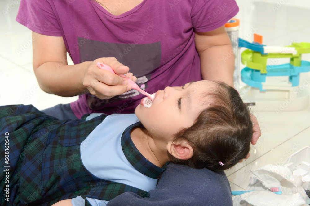 Mother teaching her little daughter to brush her teeth Mother teaching her little daughter to brush her teeth