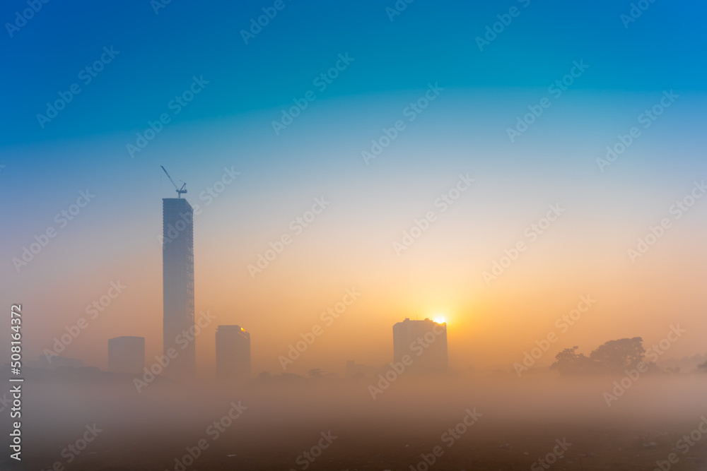 Beautiful image of sunrise at Kolkata maidan in a foggy winter morning. Sunrises at the horizon above Kolkata (formerly Calcutta) city skyscappers. Beautiful image of sunrise at Kolkata maidan in a foggy winter morning. Sunrises at the horizon above Kolkata (formerly Calcutta) city skyscappers.