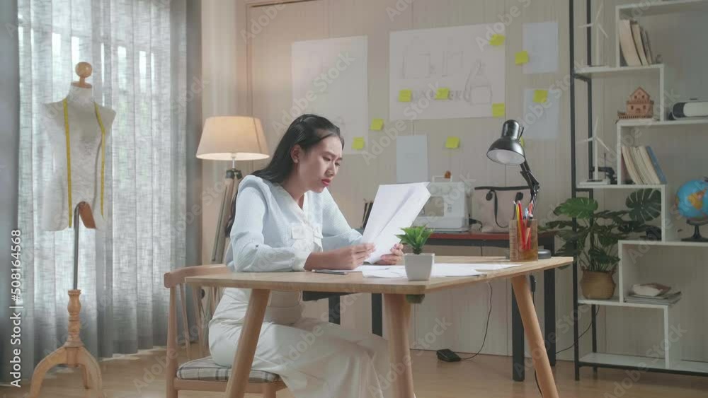 Upset Asian Woman Bag Designer Positively Shaking Her Head While Looking At The Layout Bond At The Office

