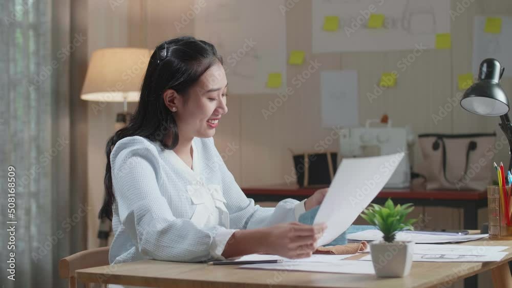 Asian Woman Designer With Layout Bond Looking At The Fabric In Hands
Asian Woman Designer With Layout Bond Looking At The Fabric In Hands