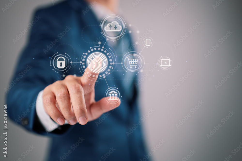 On a virtual screen, a businessman tapping his fingerprint scan gives a secure payment, banking, and cloud computing network connection interface. On a virtual screen, a businessman tapping his fingerprint scan gives a secure payment, banking, and cloud computing network connection interface.