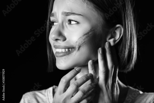 Bruised young woman on blac...