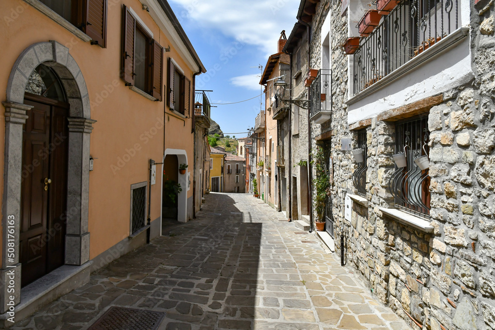 A narrow street between the old houses of Sasso di Castalda, a village in the mountains of Basilicata, Italy.