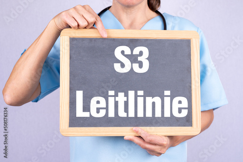 Ärztin mit einer Tafel auf der S3 Leitlinie steht