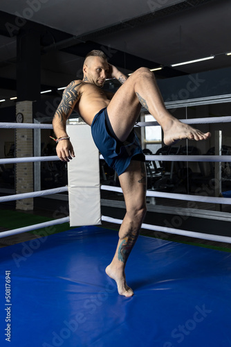 Professional muay thai fighter demonstrates kneeling attack technique (flying knee) photo