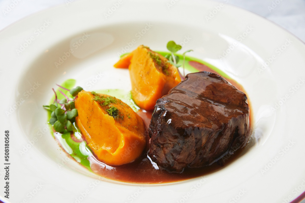 Delicious steak with batata pieces and microgreen on plate Delicious steak with batata pieces and microgreen on plate
