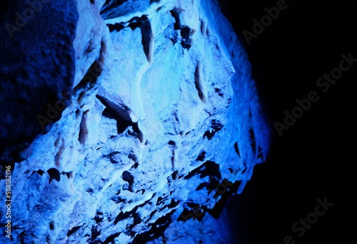 Formation rocheuse calcaire au cœur d'une grotte, éclairée par une lumière bleue photo