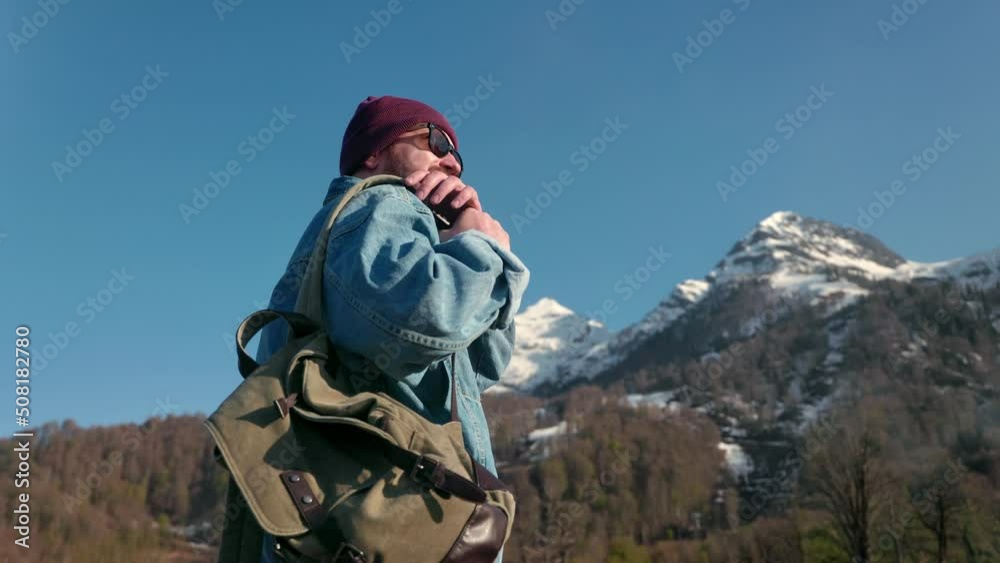Smiling male backpacker admiring sunny snowy mountain landscape enjoy freedom travel vacation Smiling male backpacker admiring sunny snowy mountain landscape enjoy freedom travel vacation