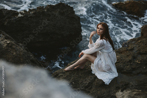 Fototapeta Naklejka Na Ścianę i Meble -  Woman in white dress rocky company nature ocean waves unaltered