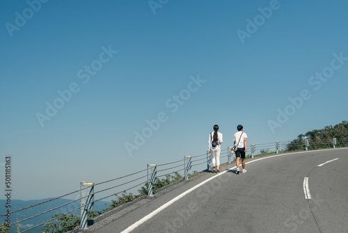 young asian couple walking together on a lonely road in the mountains
