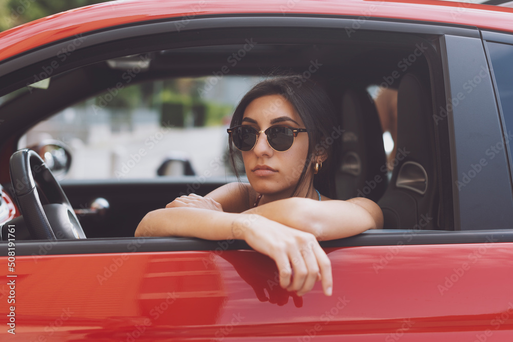 Portrait of beautiful young woman sitting in a car