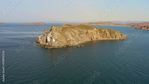 Beautiful island with high vertical rocks among the sea at dawn. Nesting place for seabirds. Untouched nature. Drone view. Klykov Island, Sea of Japan. Vladivostok photo