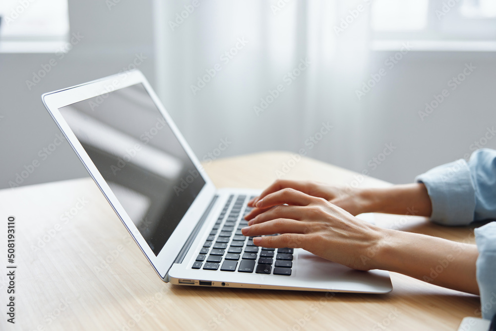 Closeup shot of woman's hands typing documents report answer using laptop keyboard staying on the table in office. Modern Online Job Work in Social Media concept