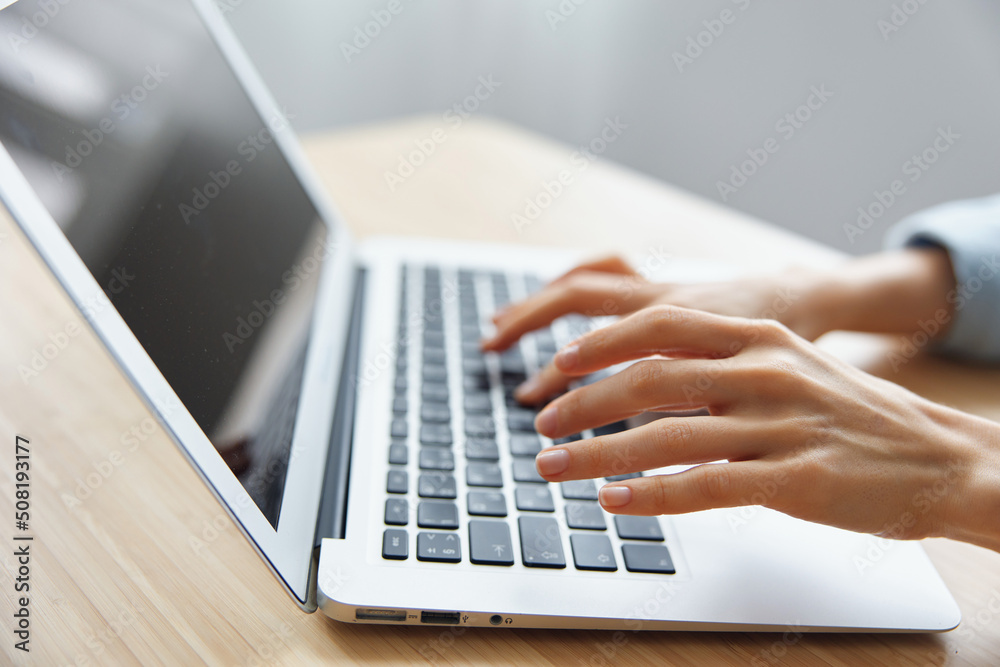 Closeup shot of woman's hands typing documents report answer using laptop keyboard staying on the table in office. Modern Online Job Work in Social Media concept Closeup shot of woman's hands typing documents report answer using laptop keyboard staying on the table in office. Modern Online Job Work in Social Media concept