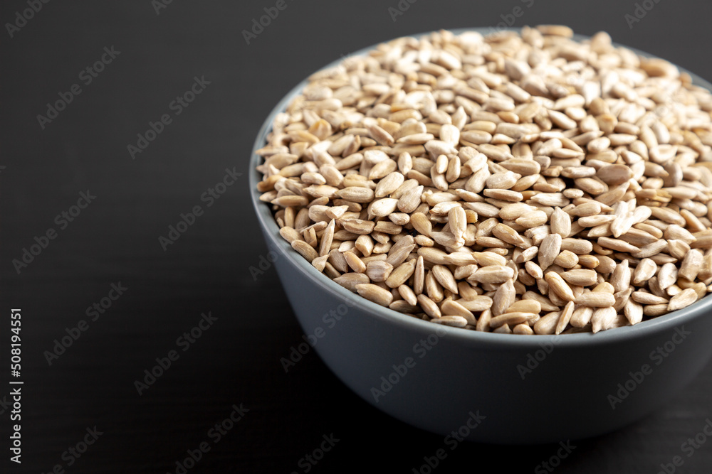 Raw Organic Sunflower Seed Kernels in a Blue Bowl, side view. Space for text.