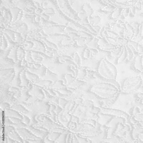 White lace fabric with a floral ornament. A feminine background best for romantic invitations, bridal shower or wedding designs.