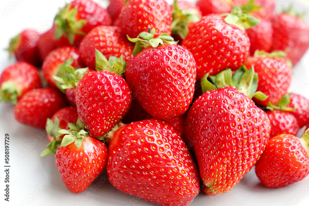 Fresh red strawberries with leaves. Pile of ripe strawberry for background Fresh red strawberries with leaves. Pile of ripe strawberry for background