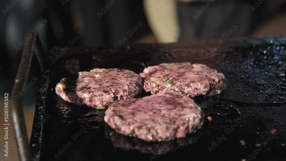 chef grilling fresh meat cutlets for burgers putting oil- Grilled Steak chef grilling fresh meat cutlets for burgers putting oil- Grilled Steak