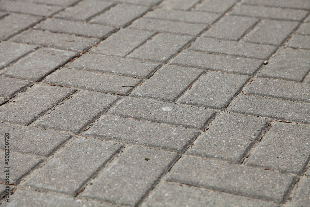 Diagonal paving tiles. Road gray background.