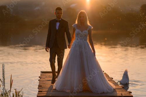 Print op canvas The bride and groom together meet the sunset