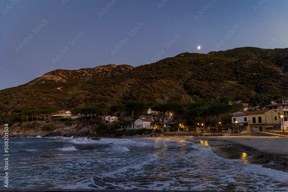 Coast and sea near Sant'Andrea on the island of Elba in Italy with blue sky in summer at dusk